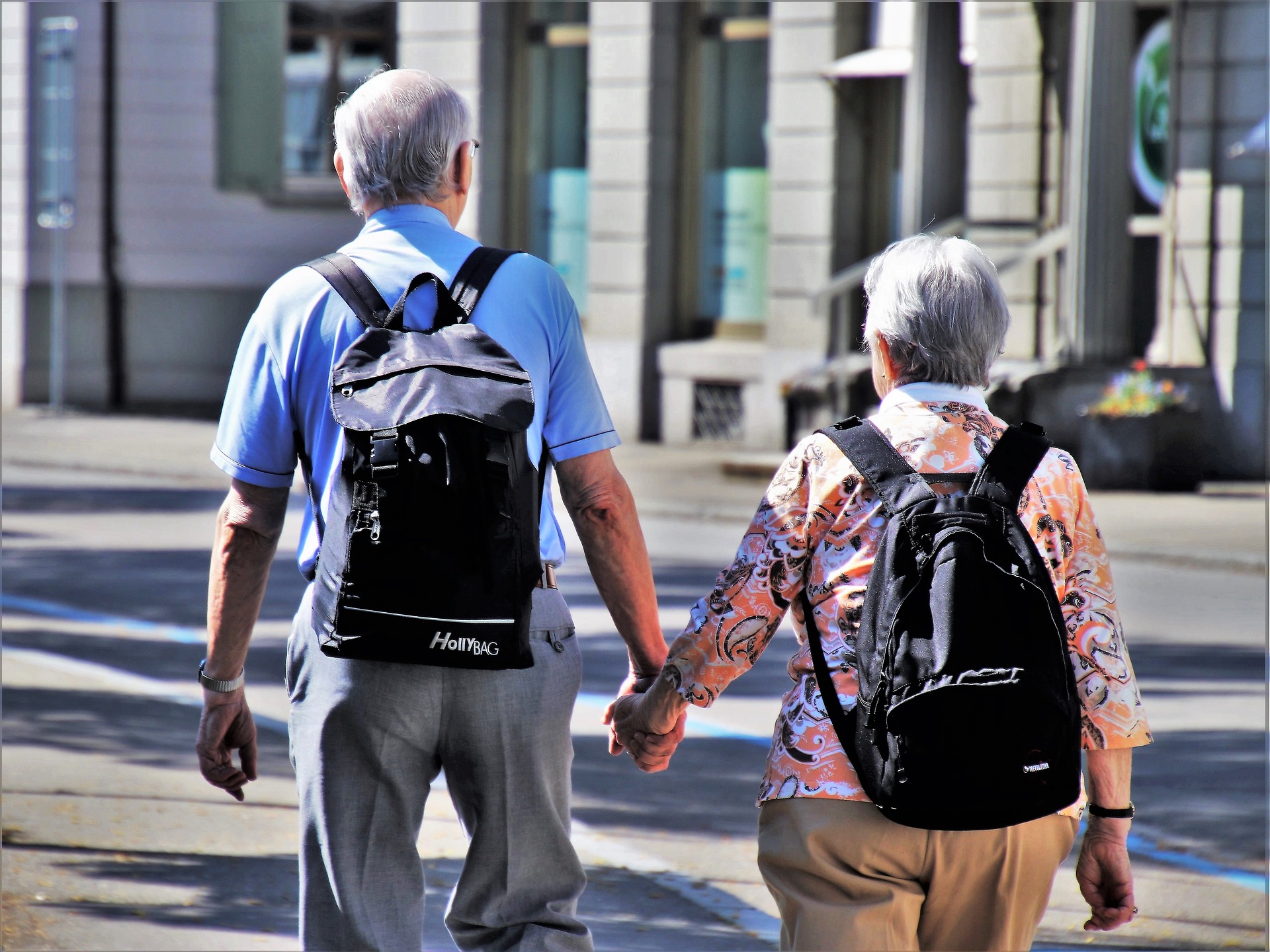 Äldre par som promenerar med ryggsäckar