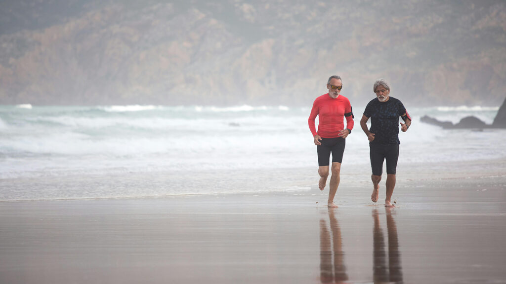 Två män som springer på strand